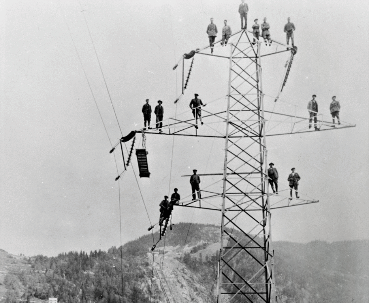 Black and white photo of men in power mast